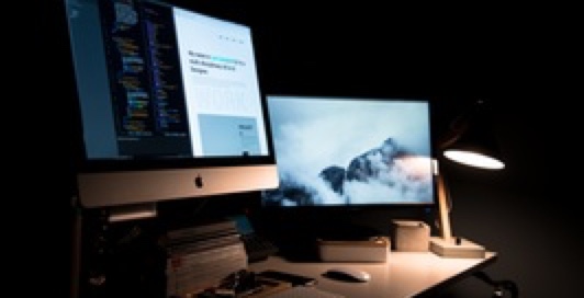 a mac computer with two displays lighted on
